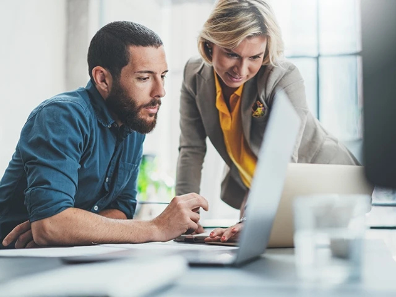 Man and woman working infront of a laptop